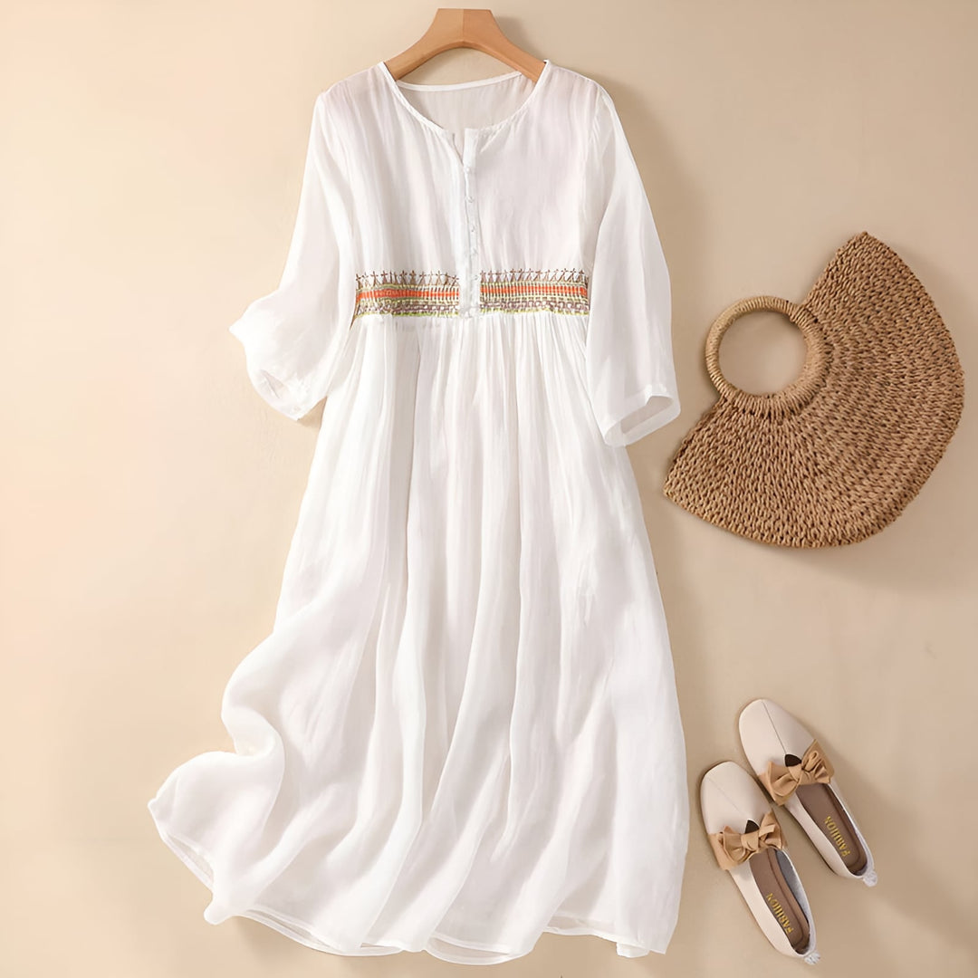 Close-up detail of delicate embroidery on a lightweight midi dress in white