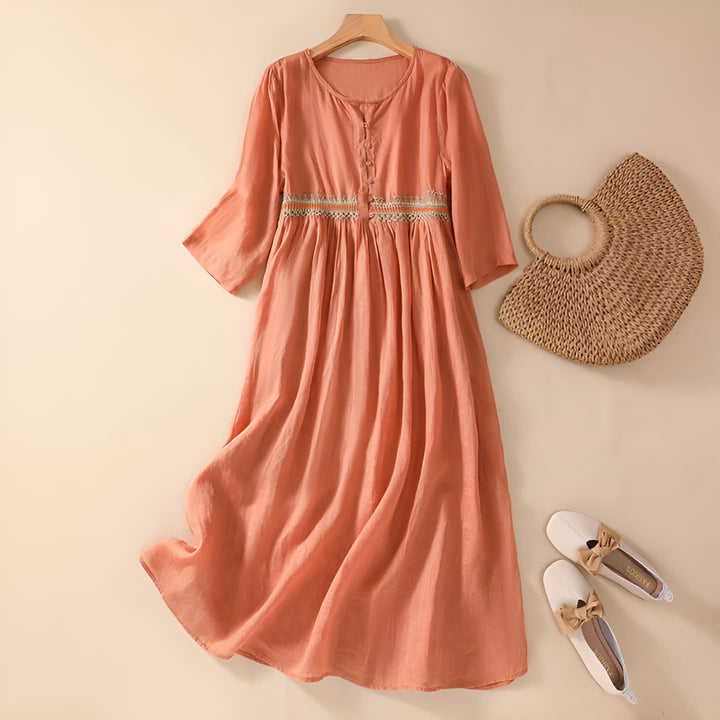 Woman in an orange embroidered midi dress showing the relaxed, flowing fit from the side