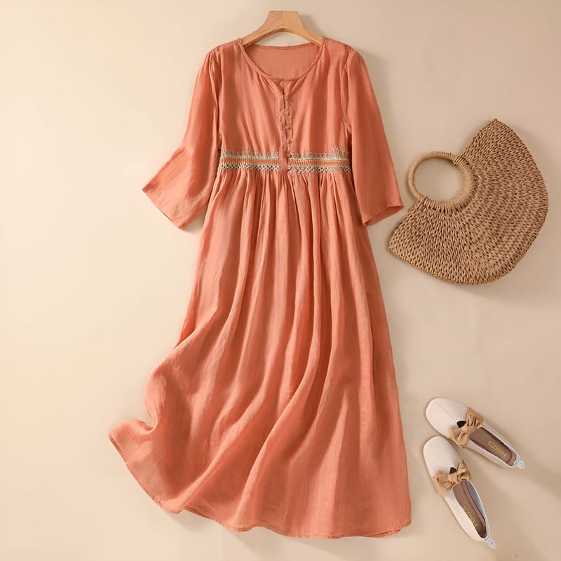 Woman in an orange embroidered midi dress showing the relaxed, flowing fit from the side