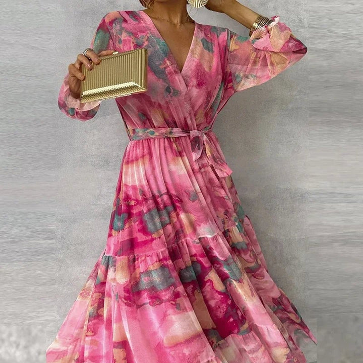 Front view of an elegant handmade floral midi dress with a cinched waist tie and layered skirt in bold colors