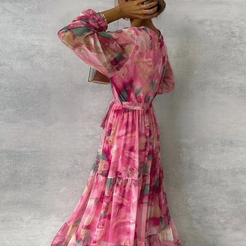 Model in a flowing floral dress styled for a garden party, showing the graceful movement of the layered skirt