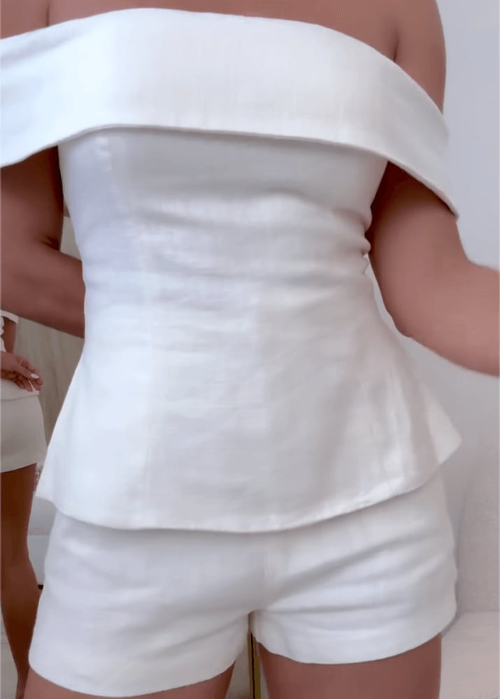White two-piece suit styled with accessories, full length view