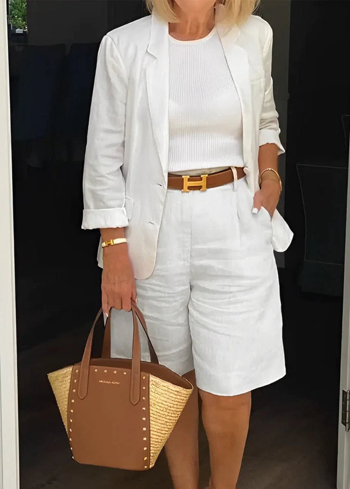 Woman wearing a white structured blazer and matching shorts two-piece suit set, front view