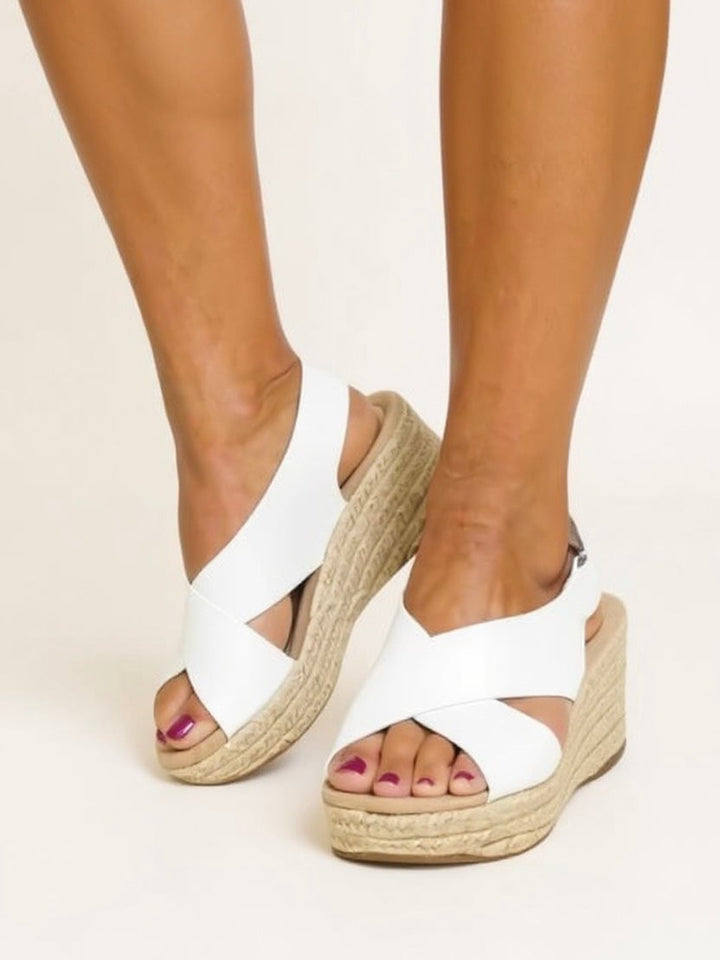 Model wearing Kendall espadrille wedge sandals in white styled with a flowy summer dress