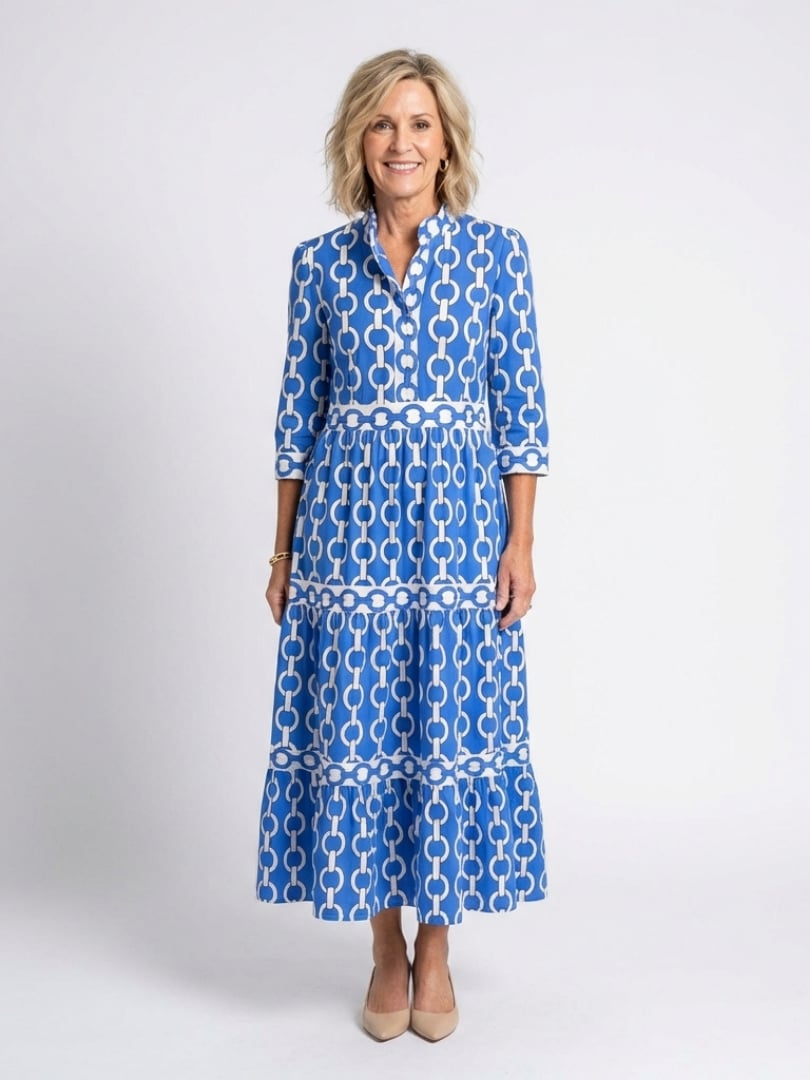 Woman wearing a blue geometric chain print tiered midi dress with 3/4 sleeves and a V-neckline