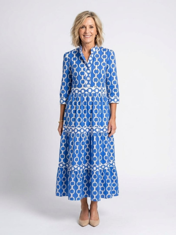 Woman wearing a blue geometric chain print tiered midi dress with 3/4 sleeves and a V-neckline