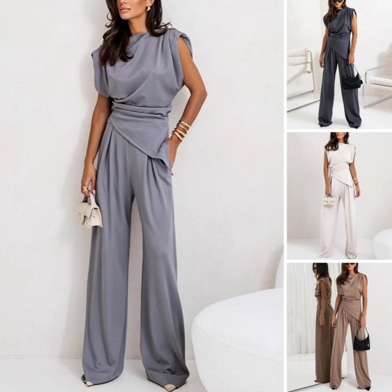 Model wearing the Khloe two-piece set in dark gray featuring a draped asymmetrical top and high-waist wide-leg pants