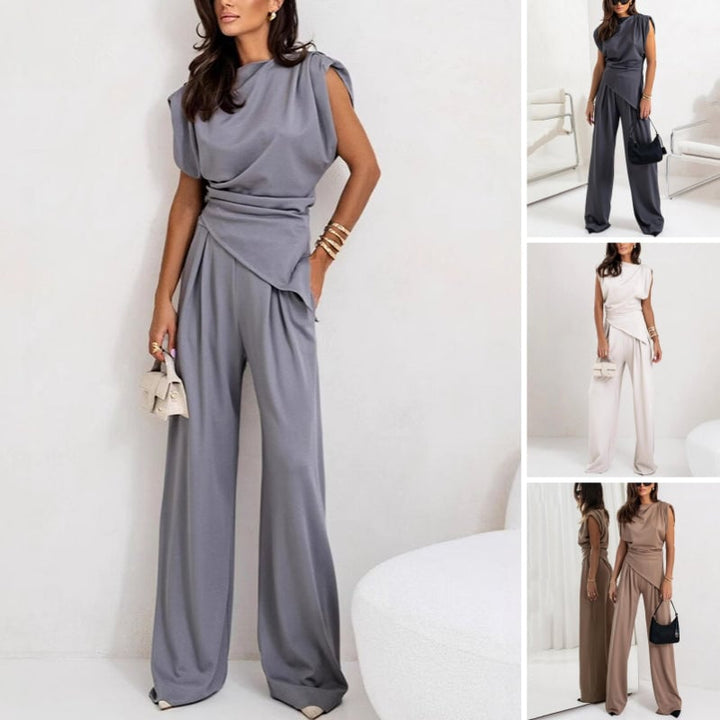 Model wearing the Khloe two-piece set in dark gray featuring a draped asymmetrical top and high-waist wide-leg pants