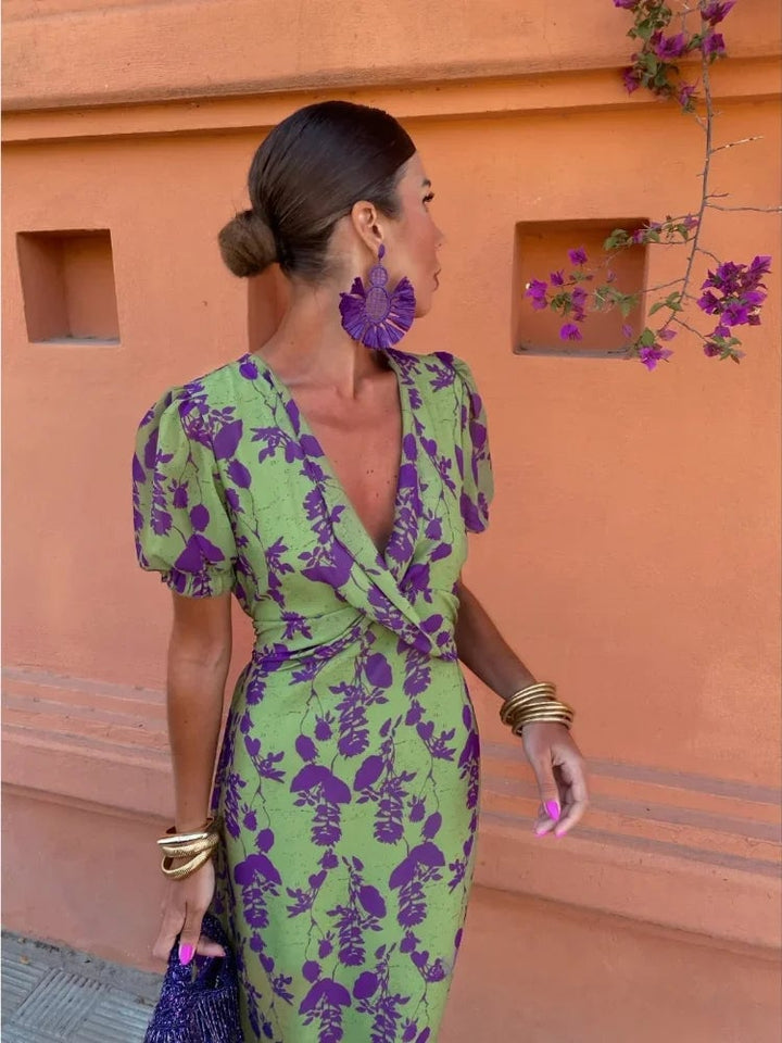 Woman wearing a green lightweight summer midi dress with V-neckline and short puff sleeves, front view