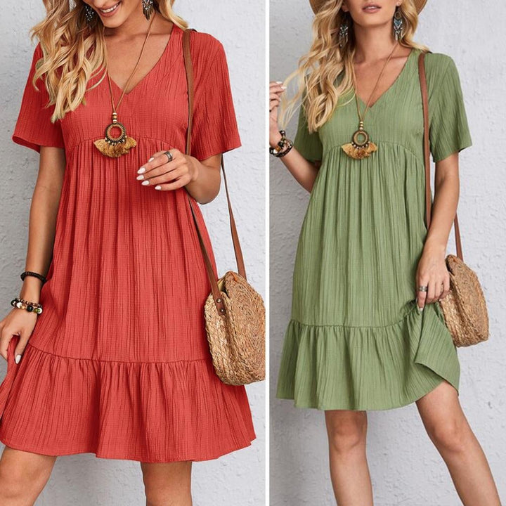 Woman wearing an elegant light green layered dress with flattering belly coverage, front view