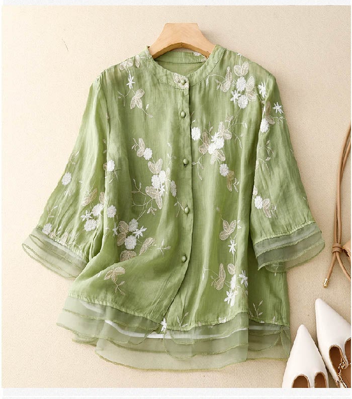 Woman wearing a green floral embroidery blouse with a relaxed fit, styled casually