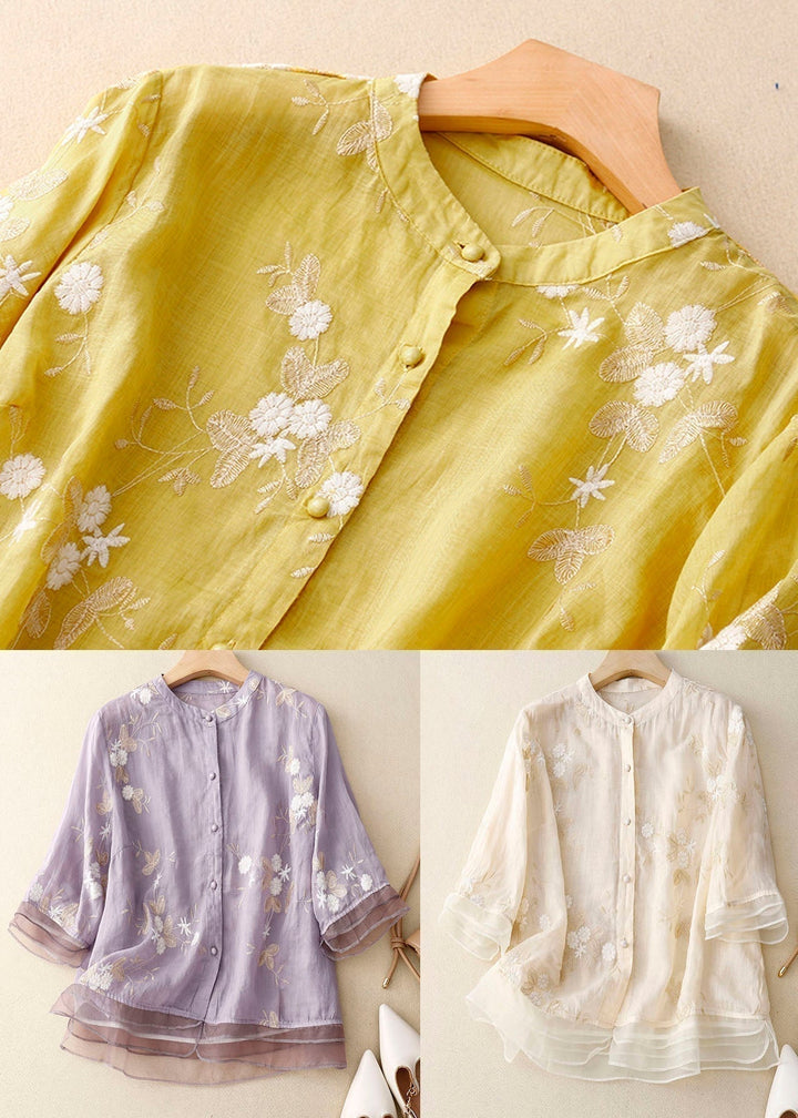 Detail shot of the button patchwork and floral embroidery on a summer blouse