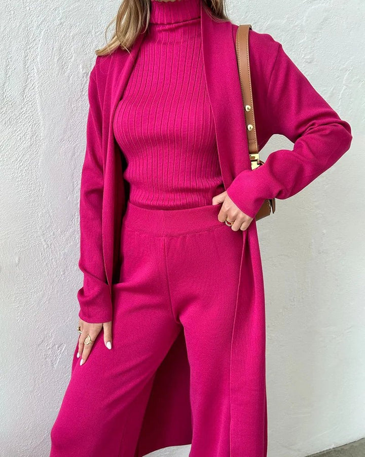 Overhead flat lay of all three Krista set pieces — vest, sweater, and trousers — in soft white
