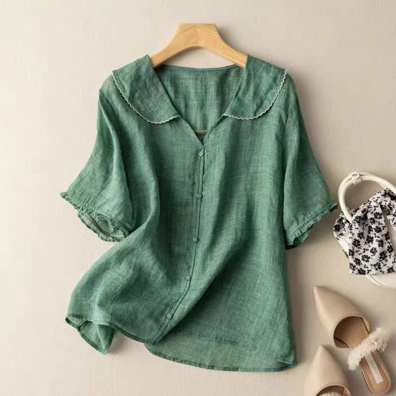 Woman wearing a relaxed vintage-style blouse with scalloped collar and button front detail in a soft neutral color