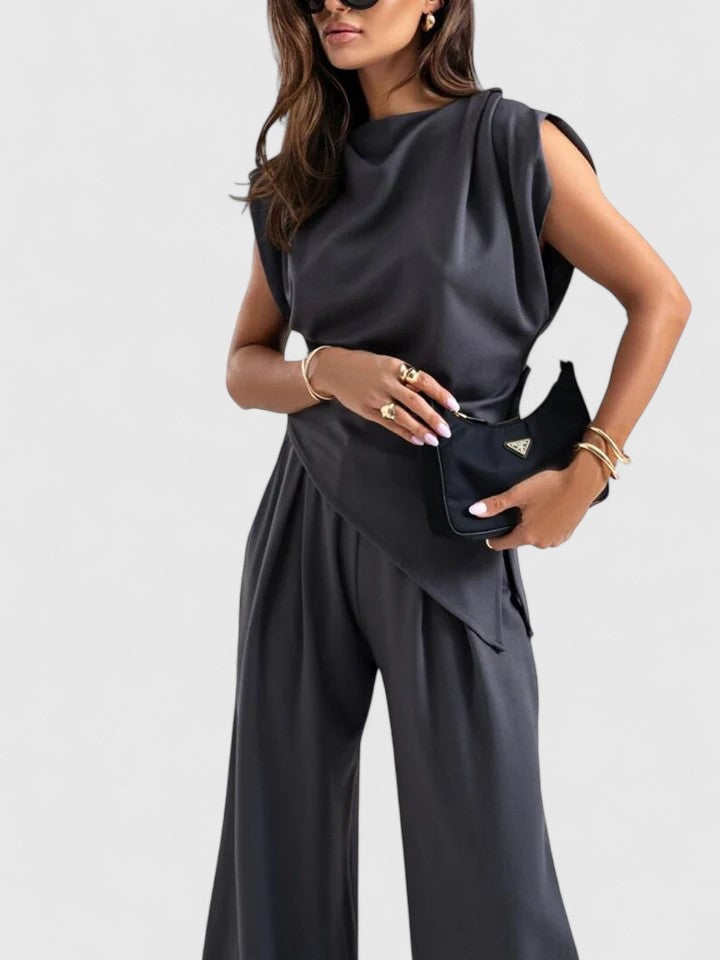 Close-up of shoulder padding and drape construction on the Laiza top in dark grey
