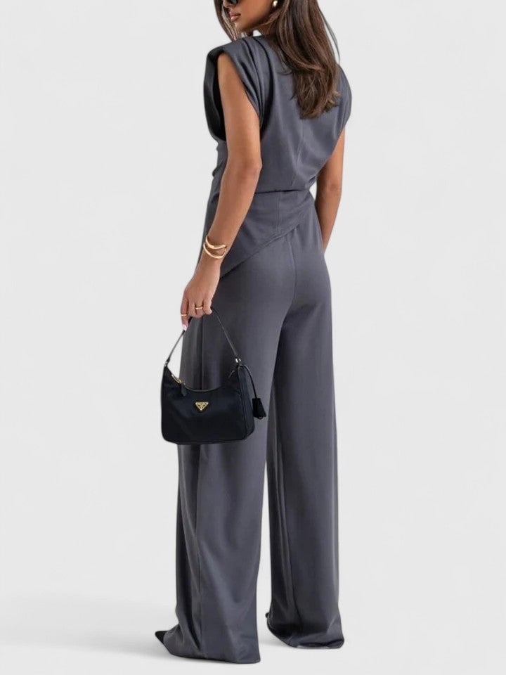 Woman wearing the Laiza draped two-piece set in light grey styled with heels