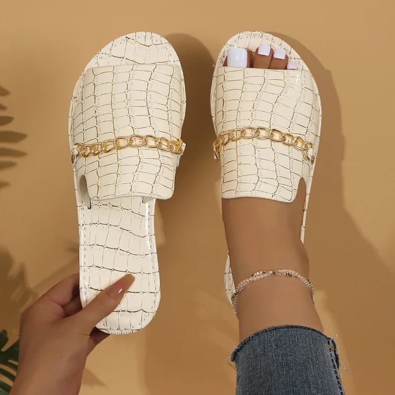 Flat lay of Lark croc-embossed sandals in multiple colors including black, red, green, gold, blue, and beige