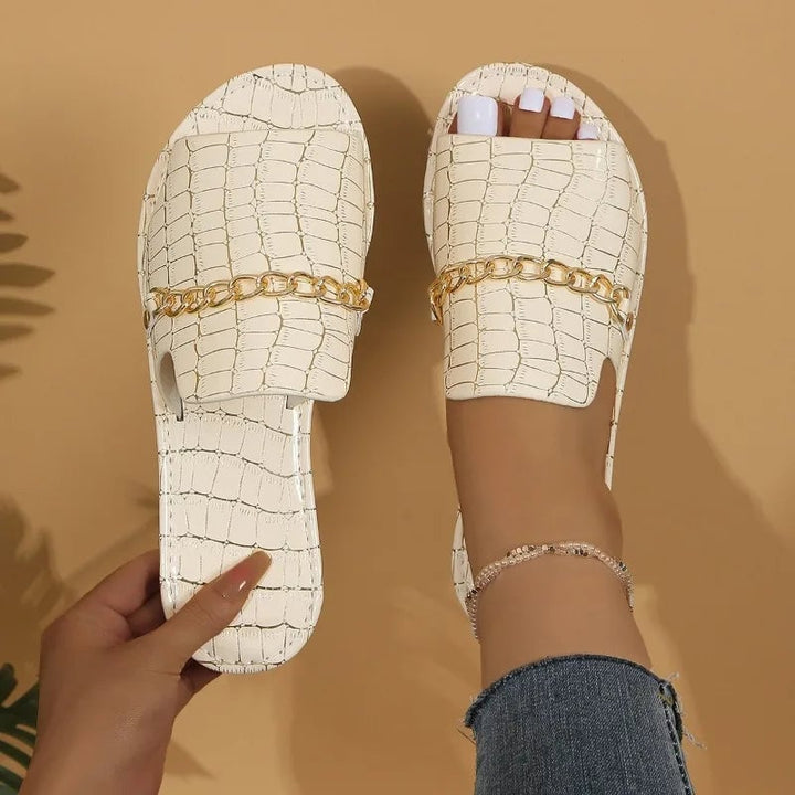 Flat lay of Lark croc-embossed sandals in multiple colors including black, red, green, gold, blue, and beige