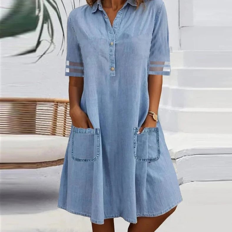 Woman wearing a blue denim mini dress with side pockets and a relaxed, flattering fit