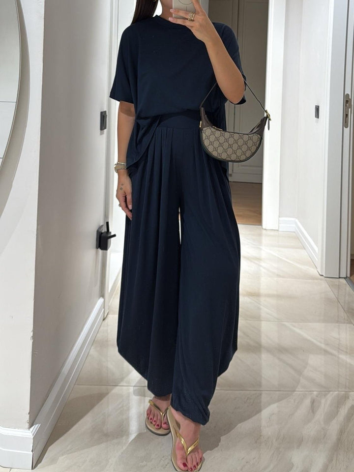 Model styled in light grey casual top and wide-leg pants set with sneakers for an everyday look