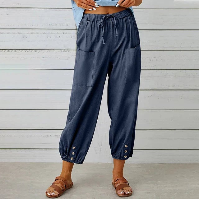 Woman wearing high waist relaxed straight-leg pants with a drawstring waist in a light neutral color, styled casually