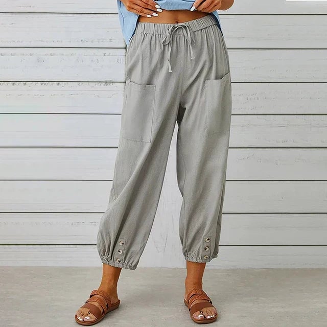 Overhead flat lay of high waist relaxed pants showing fabric texture and ankle button detail