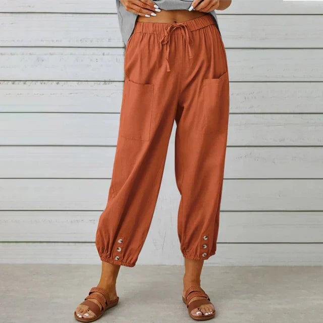 Female model wearing Lena High Waist Relaxed Pants in army green with a tucked-in blouse and sandals