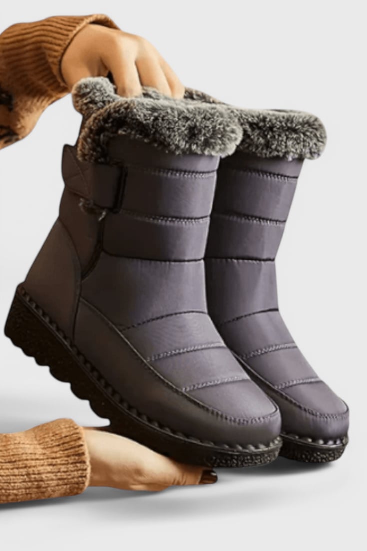 Side profile of women's waterproof boots showing textured slip-resistant outsole and smooth upper
