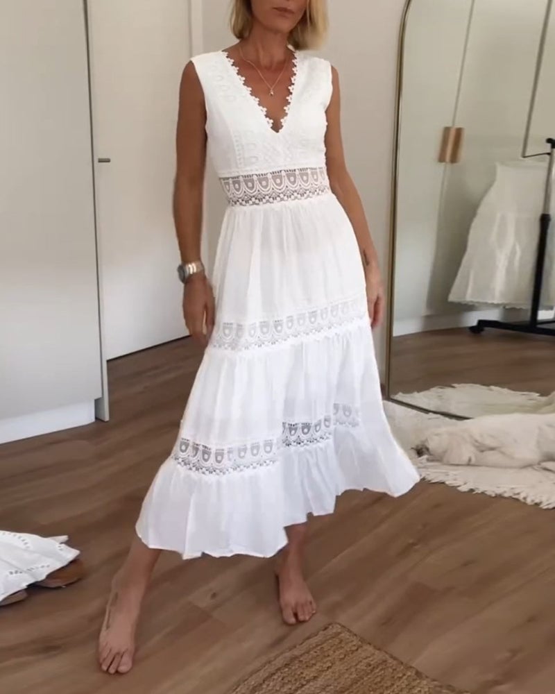 Woman wearing a white boho wrap draped dress with a tie waist, flowing skirt, and relaxed feminine silhouette