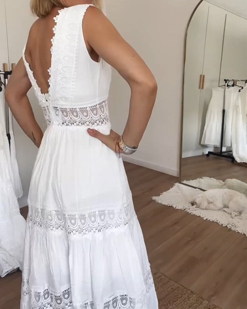 Front view of a white flowy wrap dress with adjustable tie waist and elegant drape detail