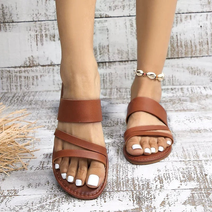 Side profile of Lilac women's flat sandal in black showing low profile and cushioned insole