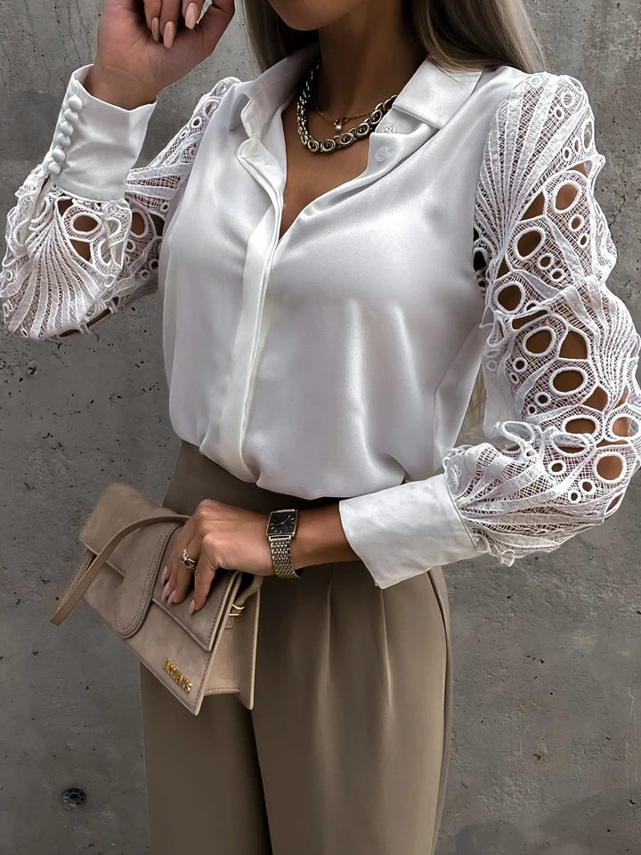 Close-up of the openwork lace sleeve detail on a women's elegant blouse in white