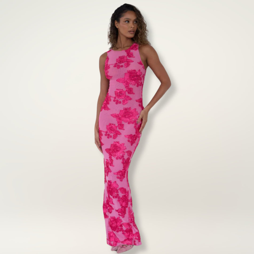 Woman wearing an elegant flowing pink floral maxi dress with a flattering waist and graceful hem