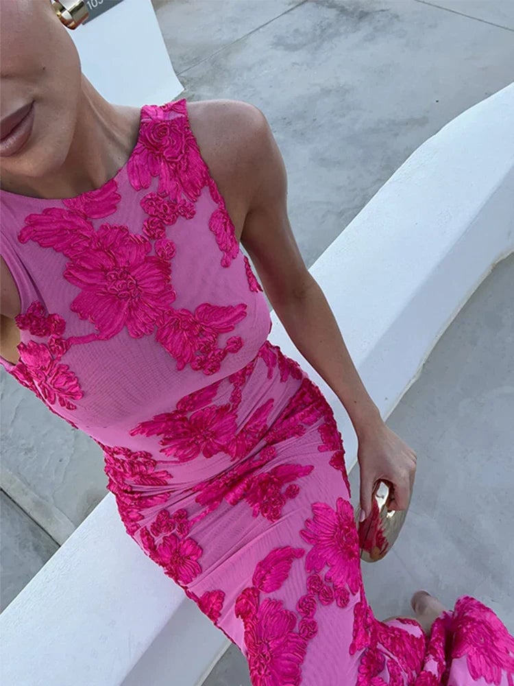 Woman in a pink floral maxi dress styled with heeled sandals for a wedding guest look