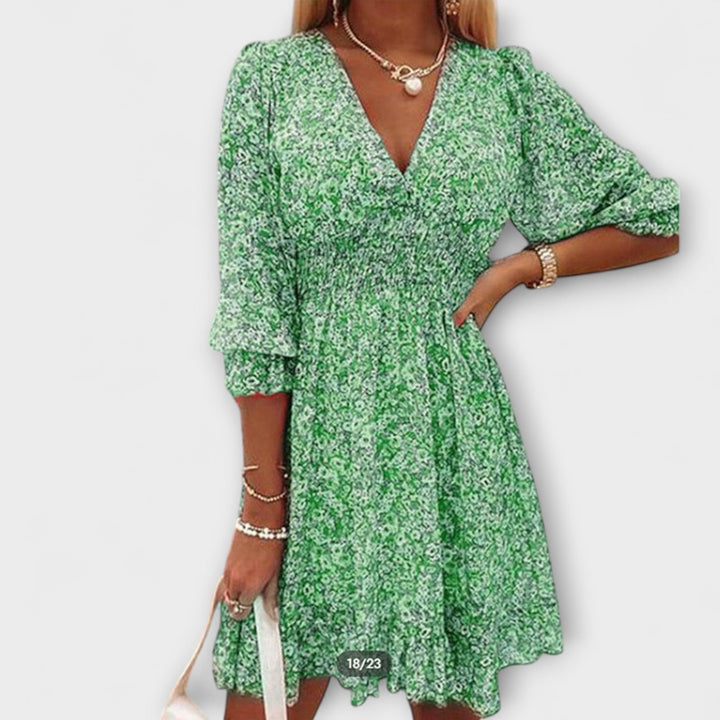 Front view of a floral puff sleeve dress in pink showing gathered waist detail