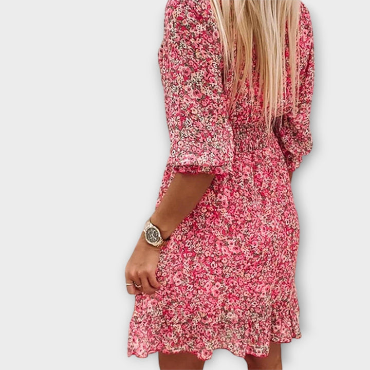 Styled flat lay of a floral puff sleeve dress with sandals and minimal accessories