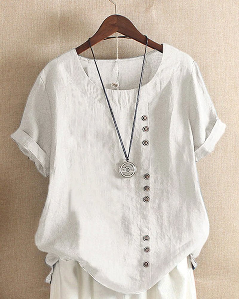 Back view of women's linen crew neck short sleeve top in pink showing relaxed fit and curved high-low hem