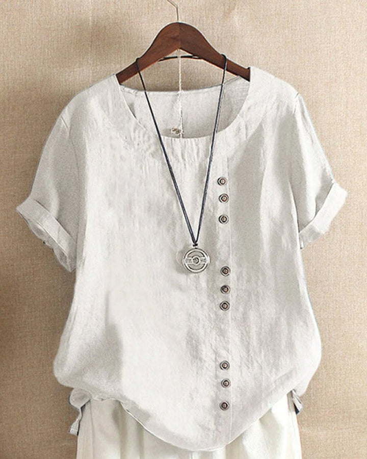 Back view of women's linen crew neck short sleeve top in pink showing relaxed fit and curved high-low hem