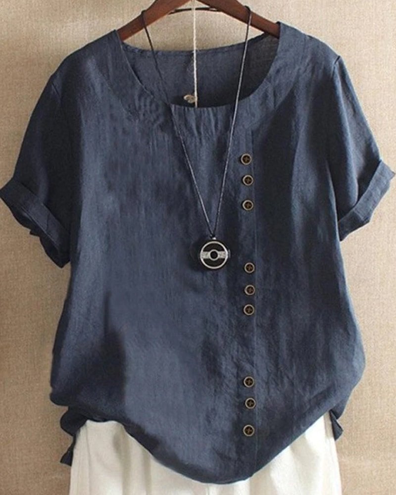 Close-up detail of tonal button placket and cuffed short sleeve on women's linen top in white