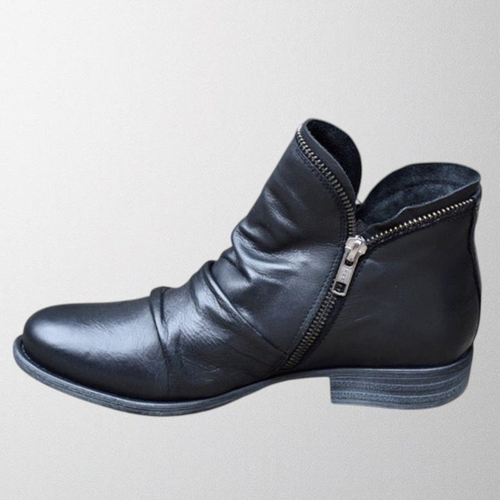 Side profile of Lisa orthopedic boots in black highlighting contoured arch support and streamlined design