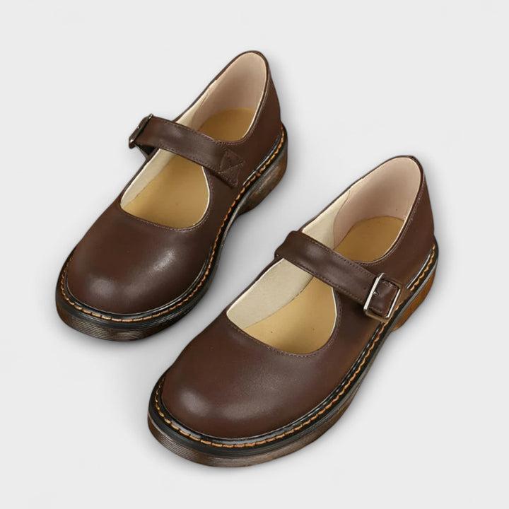 Women's brown vintage Mary Jane sandal with copper buckle strap and cushioned flat sole, front angle view