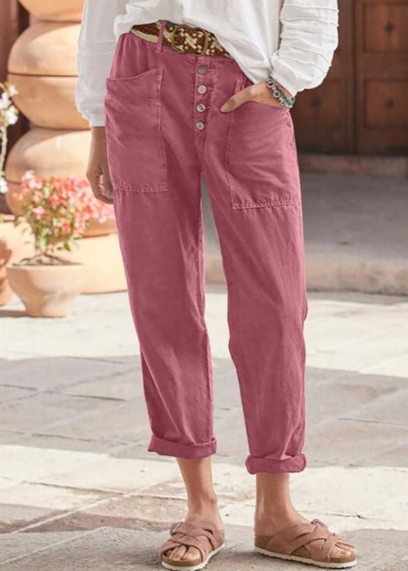 Model wearing pink high-waist relaxed trousers with subtle pleats and a flowy silhouette