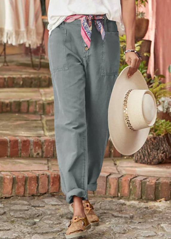 Model wearing relaxed trousers with a tucked-in fitted top and sandals