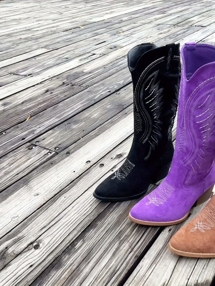 Overhead flat lay of all three suede ankle boot color options: black, brown, and purple