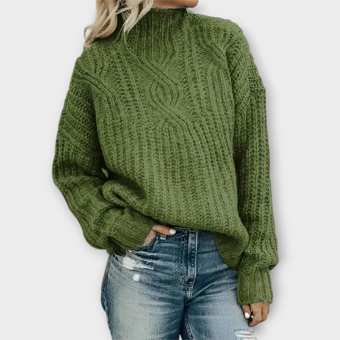 Close-up of intricate cable-knit texture on a modern high-neck sweater in a neutral tone
