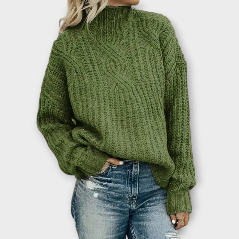 Close-up of intricate cable-knit texture on a modern high-neck sweater in a neutral tone