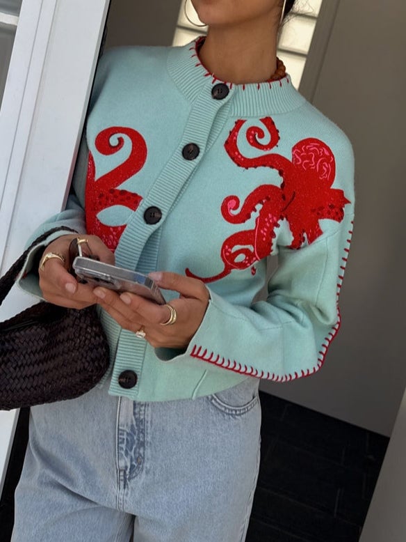 Flat lay of the mint green octopus print cardigan showing the full design and proportions