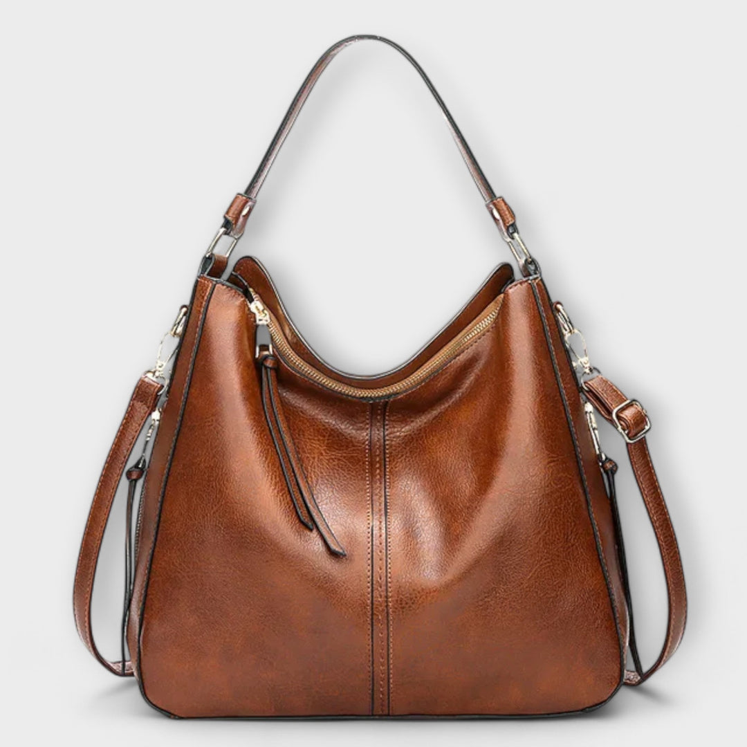 Lora shoulder bag in black with adjustable strap and structured silhouette on neutral background