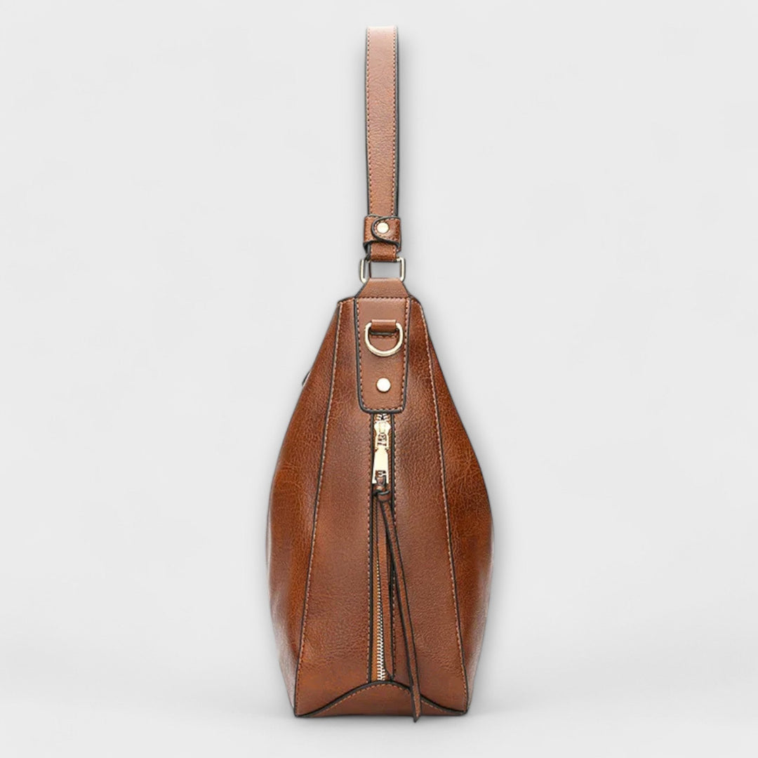 Close-up of Lora shoulder bag in brown highlighting refined hardware and strap detail