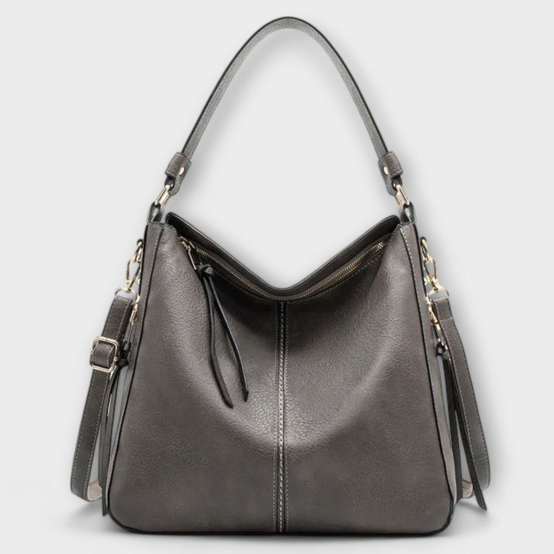 Lora shoulder bag in red held by model showing scale and proportion
